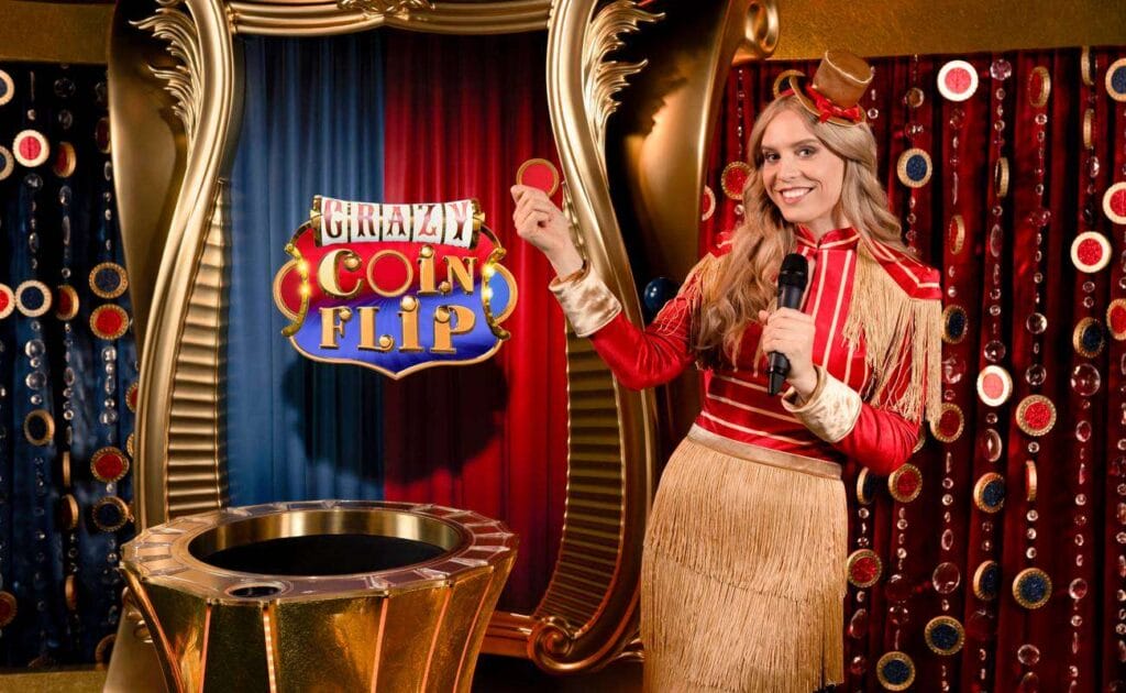 The Crazy Coin Flip live dealer game. The game host is holding a mic and the game coin while dressed in a red and gold game costume.