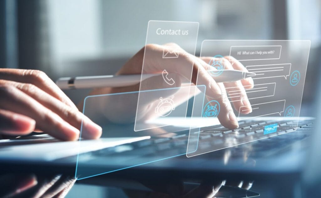 Hands on a keyboard with a chatbot conversation assistant graphic. There is a white and silver pen in the left hand.
