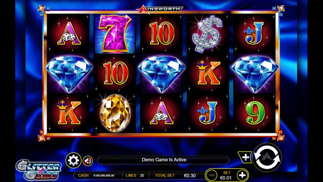 A screenshot of the Glitter Gems slot game. It features a vibrant, gem-themed interface with a dazzling blue satin-style background. In the foreground, the reels are framed in a gold border and filled with glossy, high-contrast symbols, including diamonds, golden gems, sparkling 7s, dollar signs, and traditional playing card icons. The bright red-and-black symbol backgrounds make the gems pop visually. Below the reels is the game interface.