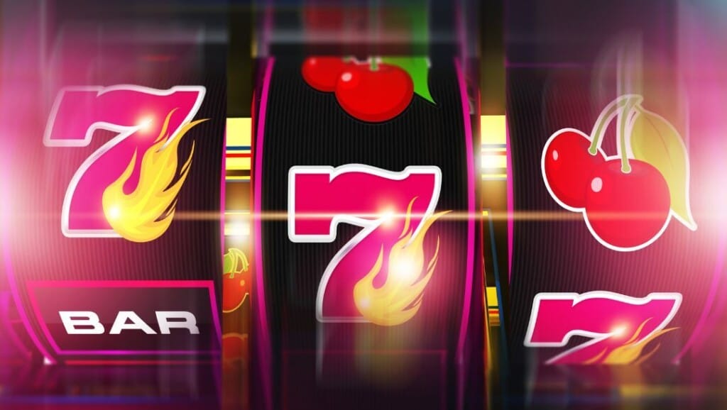 Close-up of a vibrant slot machine screen showing flaming sevens, cherries, and bar symbols. 