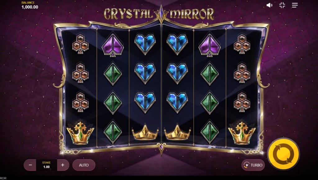 A screenshot of the slot reels in Crystal Mirror. The background is a purple cushion with small glittering gems. In the foreground are the slot reels in a gold and silver frame. The frame is filled with playing card suits in a gem style and different types of golden crowns.