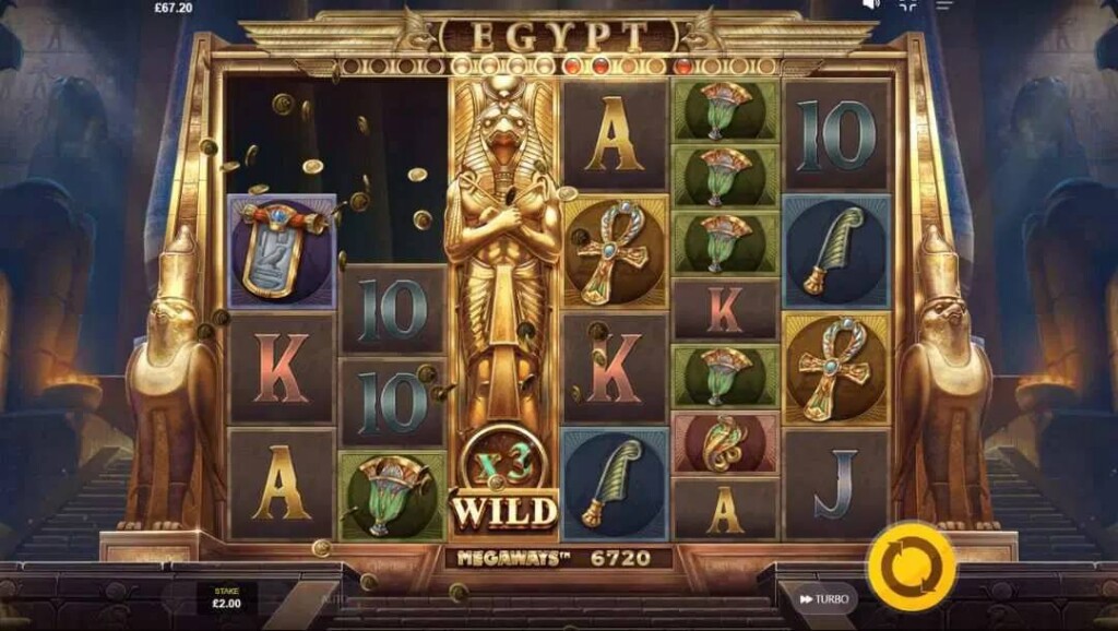 A screenshot of the slot reels in Egypt Megaways. The setting is the interior of a dark Egyptian temple. In the foreground are the game’s brightly lit, golden reels, filled with various themed and regular playing card slot symbols.