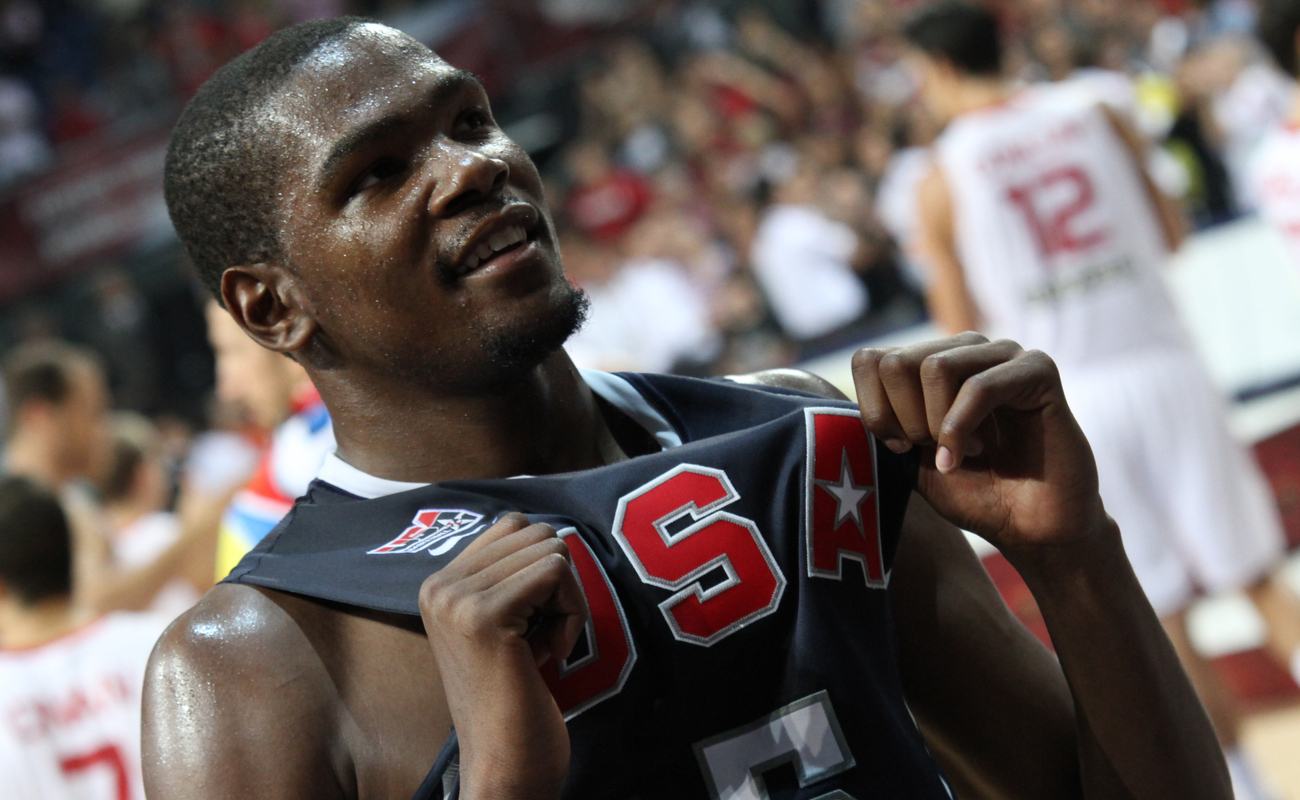 Kevin Durant holding his USA basketball jersey and smiling