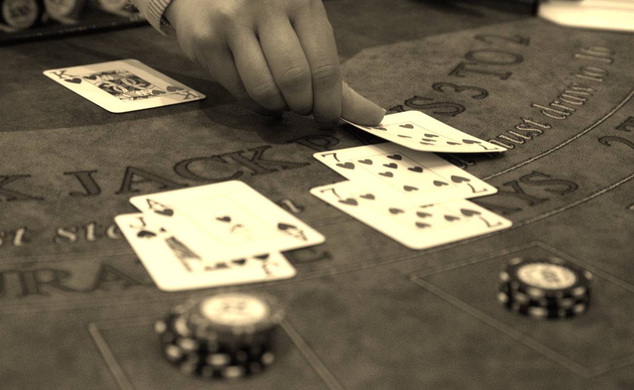 sepia photo of man dealing cards during game of blackjack