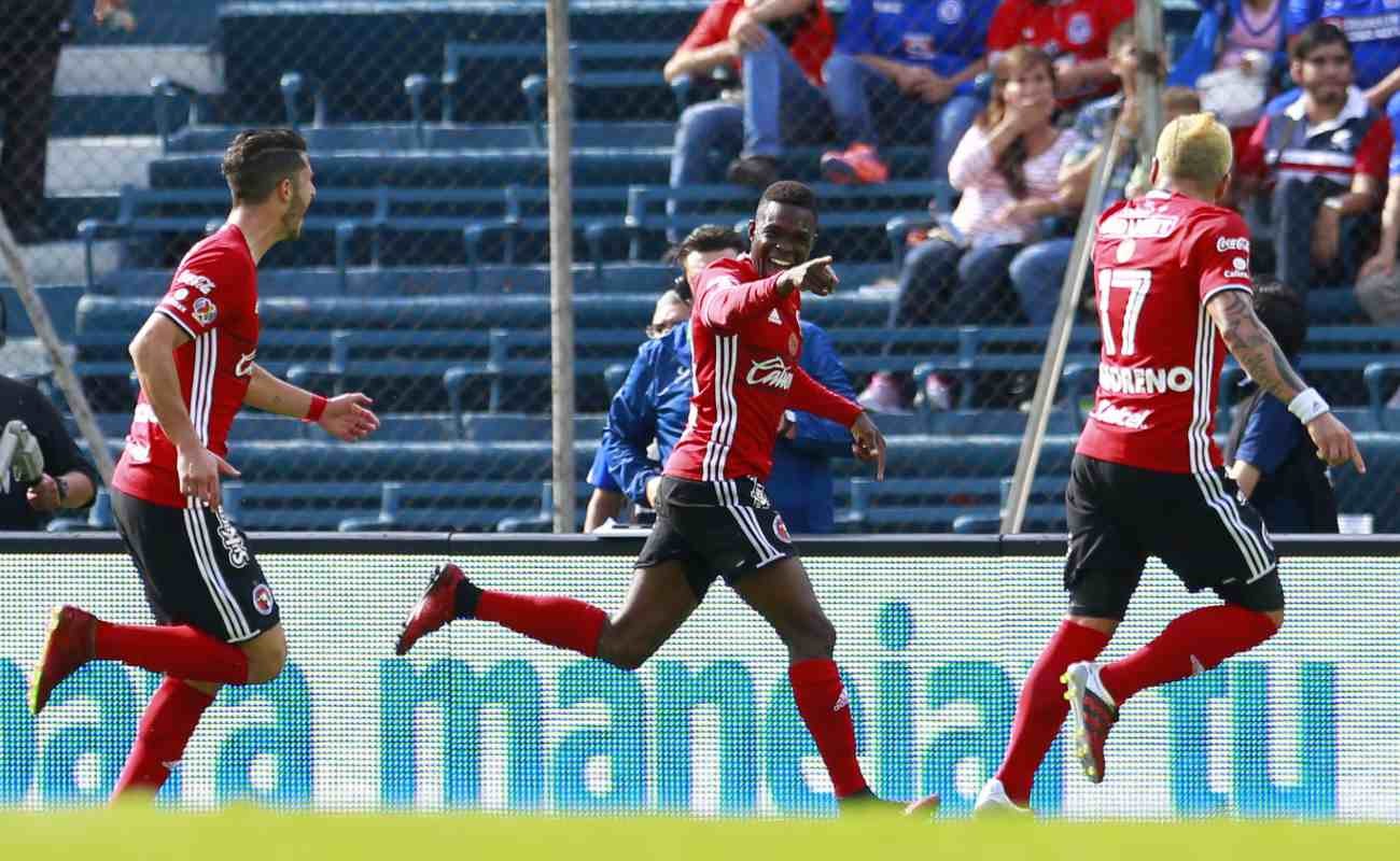 soccer player celebrates scoring a goal with teammates