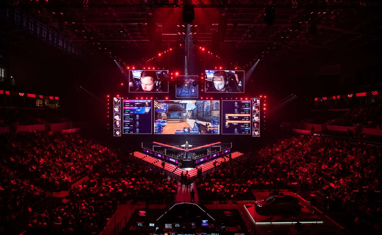 Esports counter strike global offensive match held at Moscow Russia in a packed out arena with red lighting.