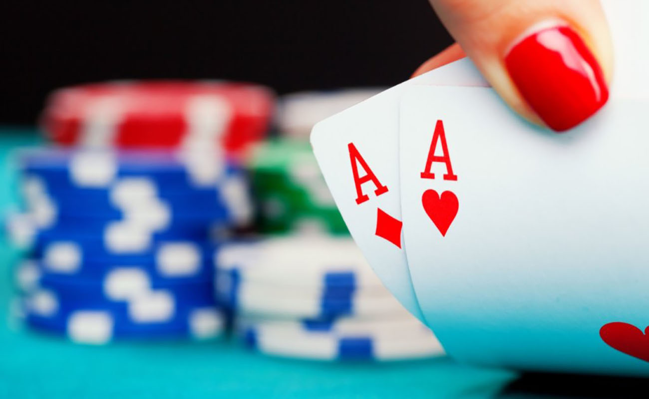 two ace cards with stacks of poker chips in the blurred background