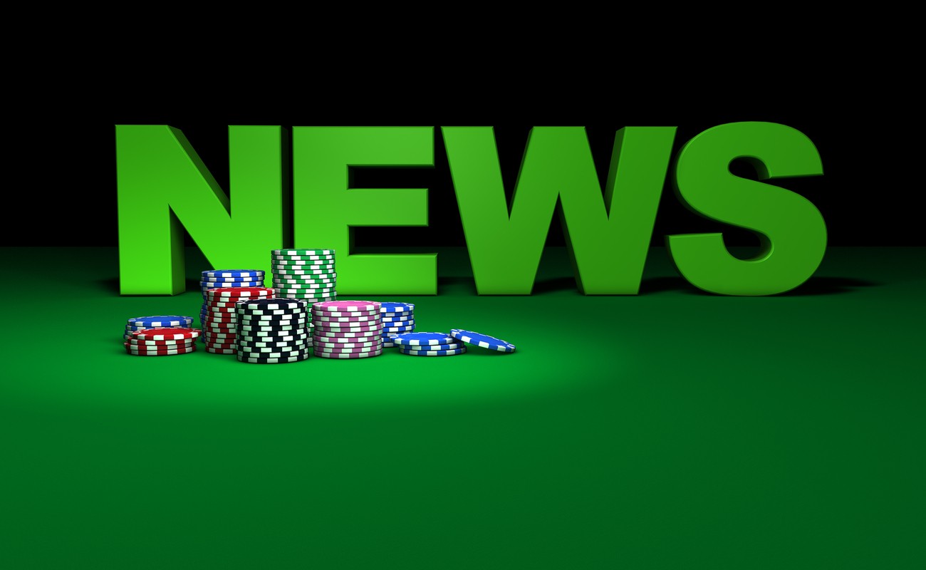 colored gambling chips and news sign on green table.