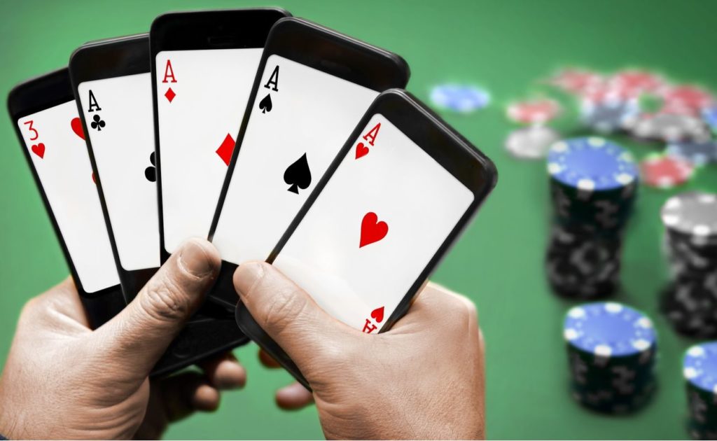 Hands holding cellphones with cards on screen
