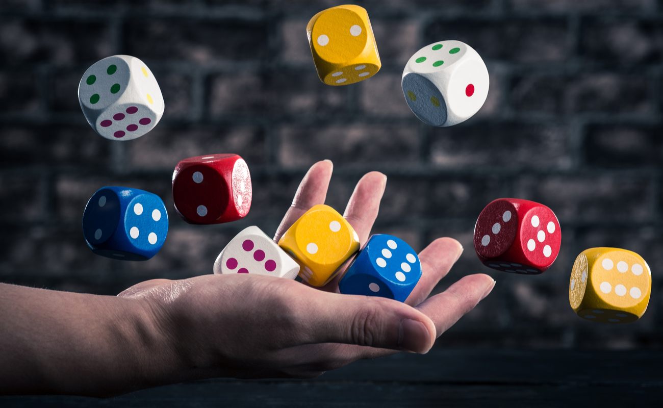 Multicolour dice thrown in the air by hand