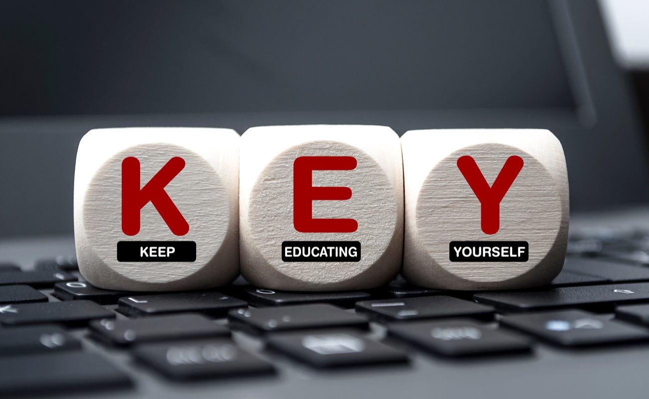 Cubes dice on keyboard with the words KEY Keep Educating Yourself