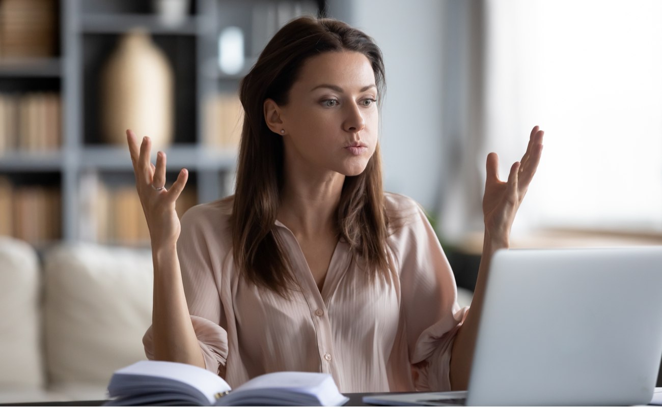 Irritated young woman looking at laptop screen