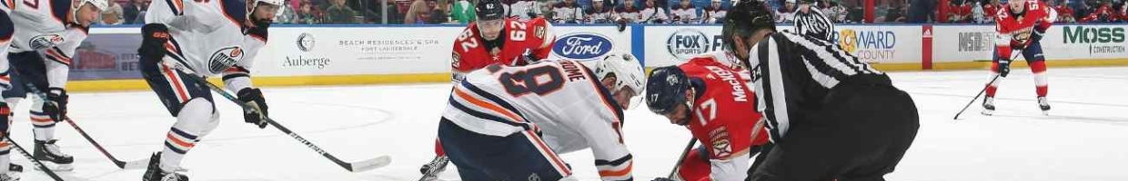 Edmonton Oilers vs Florida Panthers, players reaching for the puck with the referee watching on