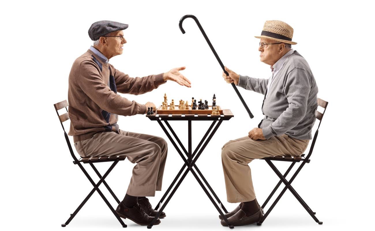 Seniors playing a game of chess and arguing isolated on white background