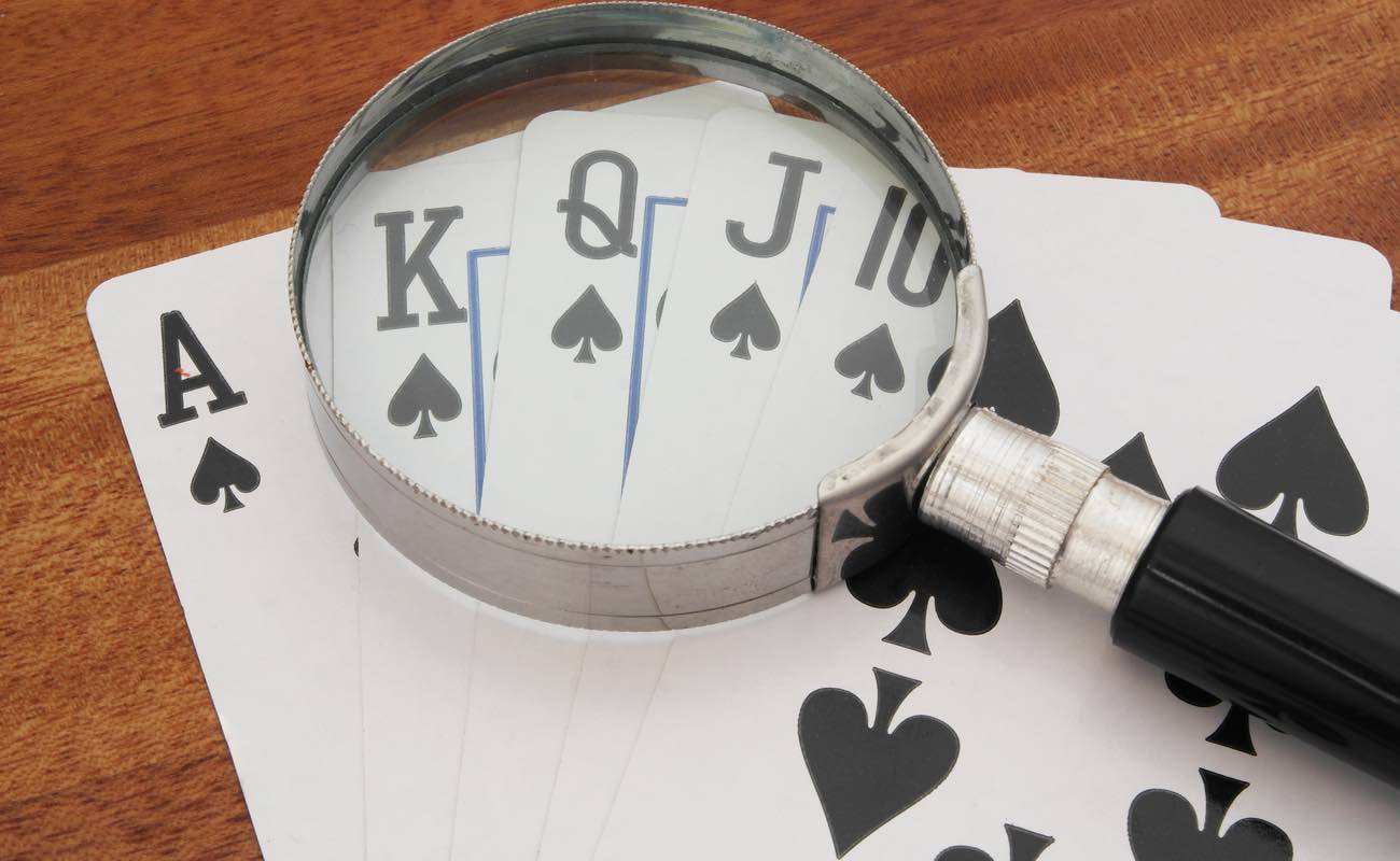 Magnifying glass over playing cards