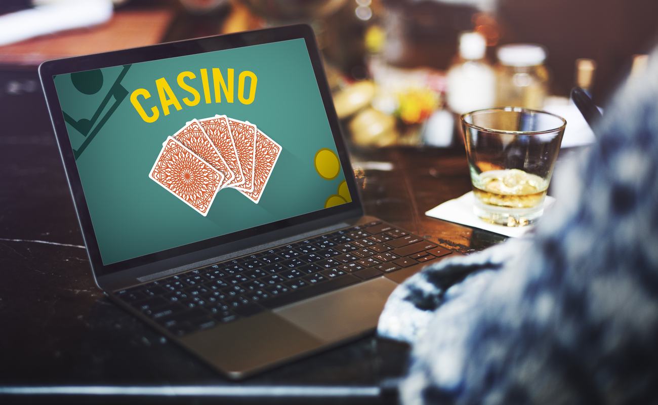 A person plays online casino games while enjoying a drink