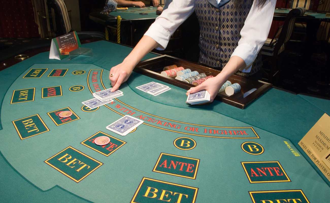 A dealer places cards on a casino game table.