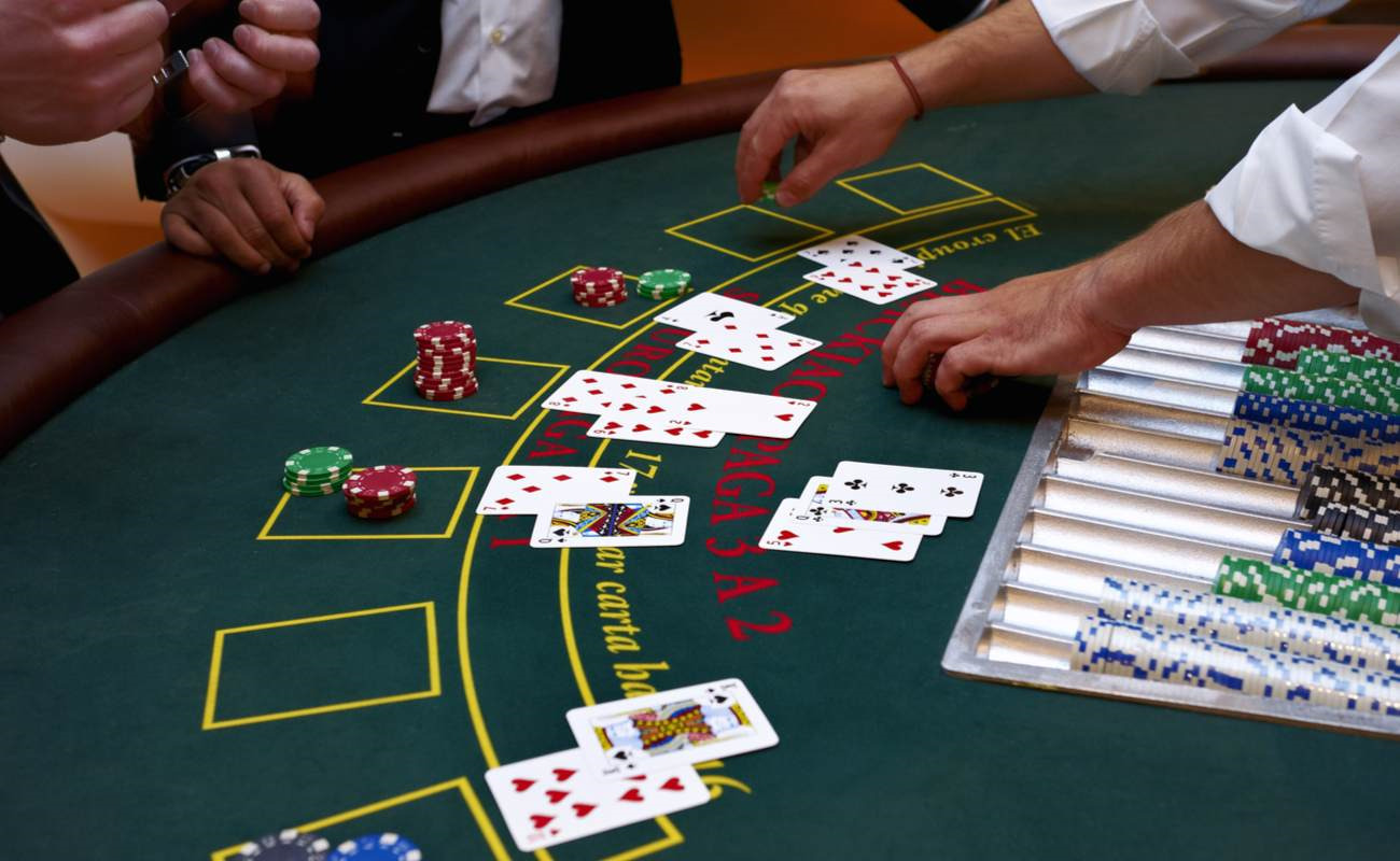 A close-up of a blackjack table with people playing.