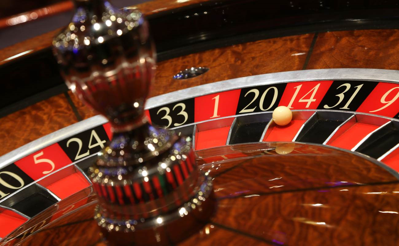 A roulette ball sits on red, number 14 on the roulette wheel.