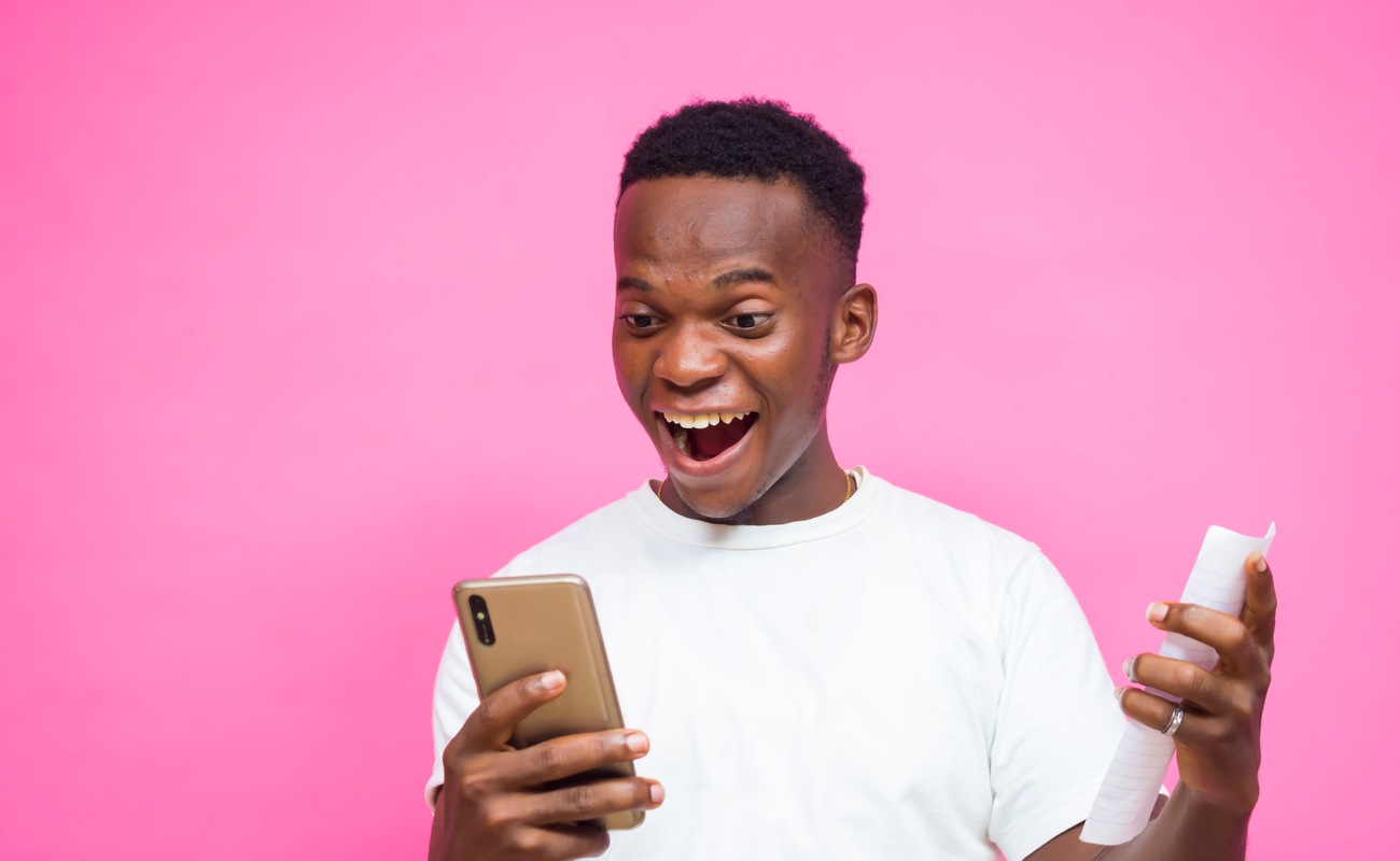 A young man feeling happy after winning a sports bet.