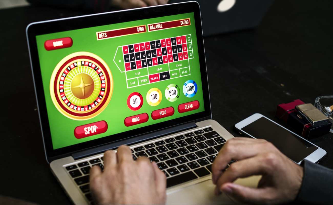 Close up of man playing online casino games on a laptop