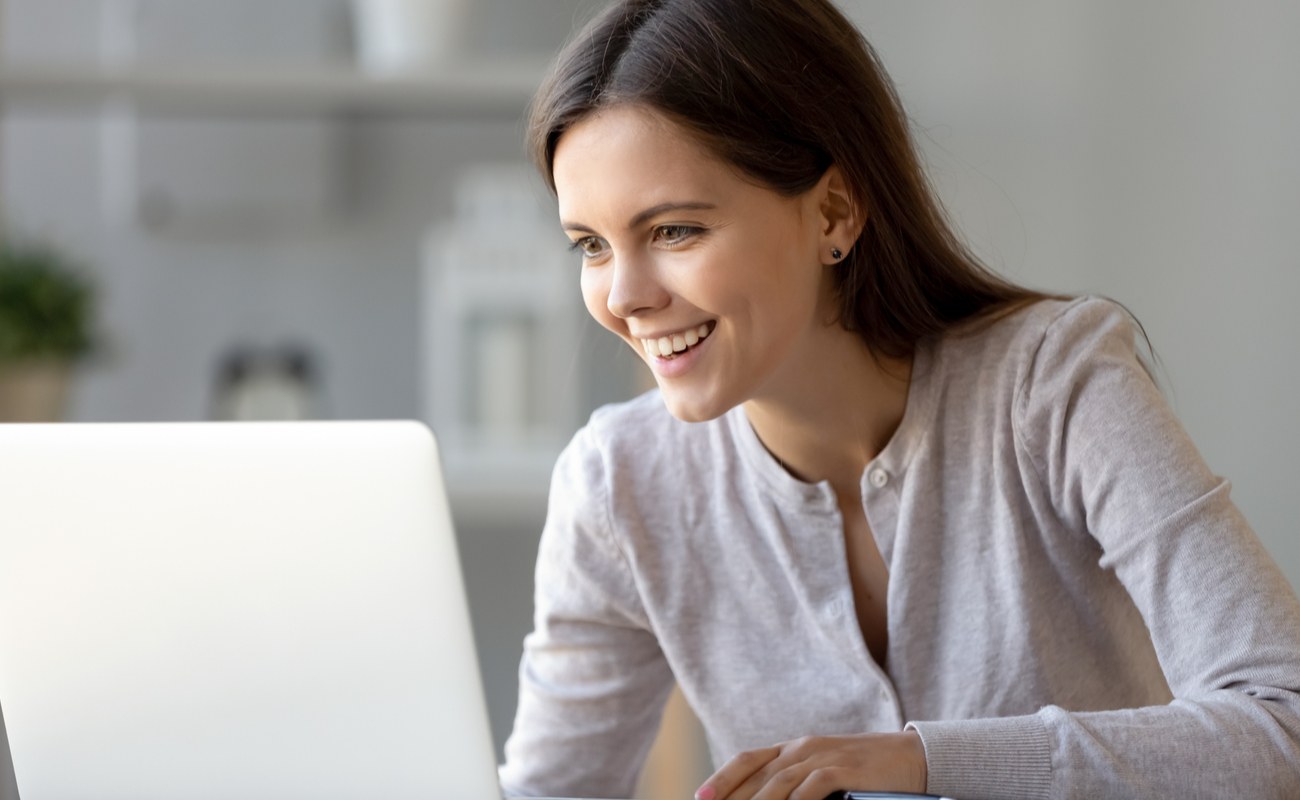 A young woman happily learns how to play online poker.
