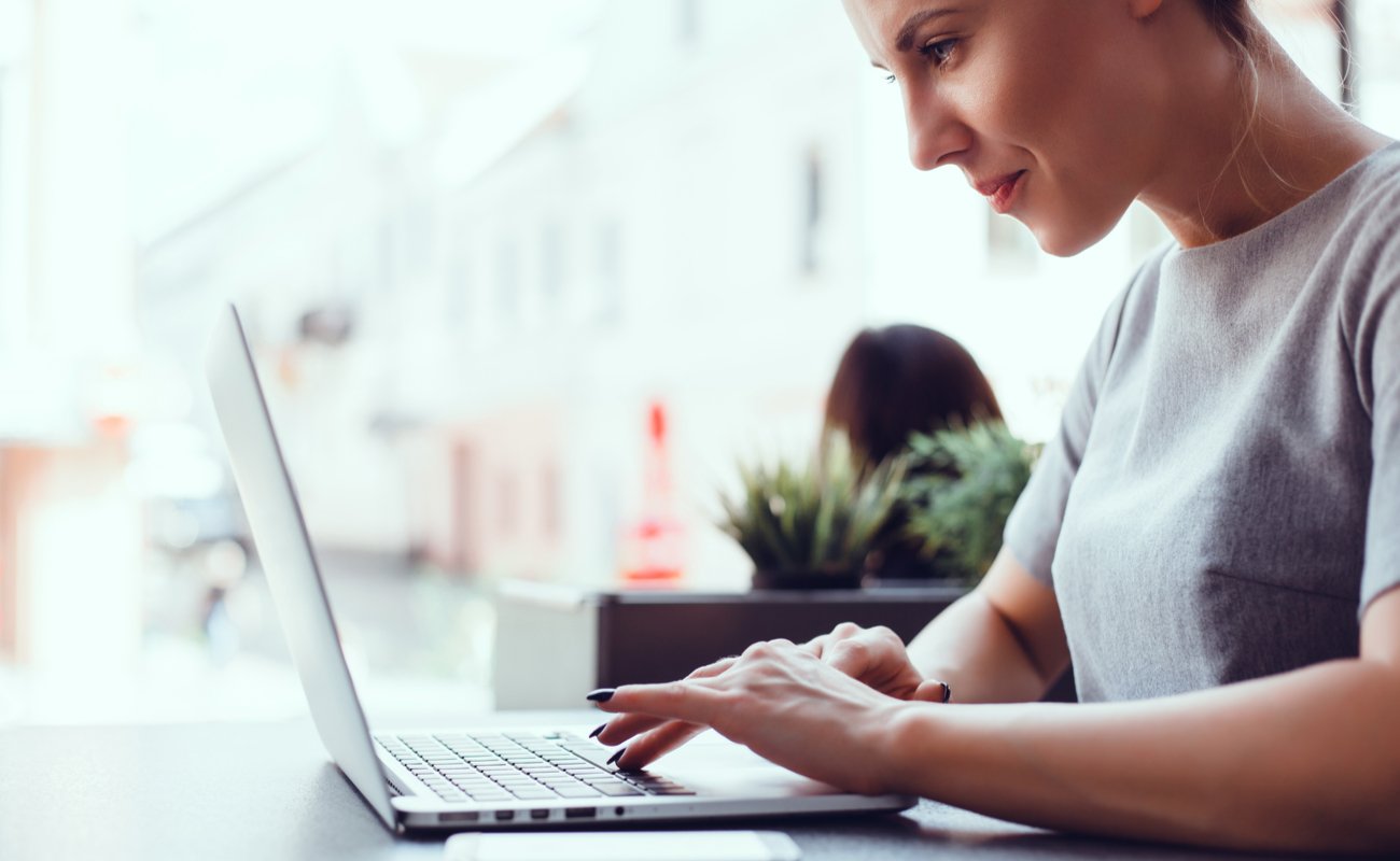 A woman works on her Mac laptop.