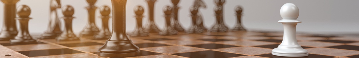 Close-up of a chessboard where a white pawn faces a black king. 