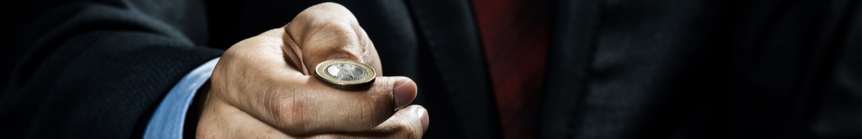 Close-up of a businessman about to toss a coin.
