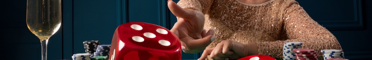 A woman throws the dice onto a green felt casino table.