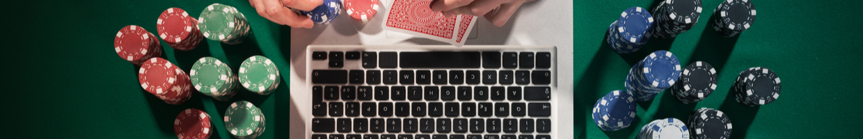 Overhead view of a person with cards and chips with a keyboard in front of them.