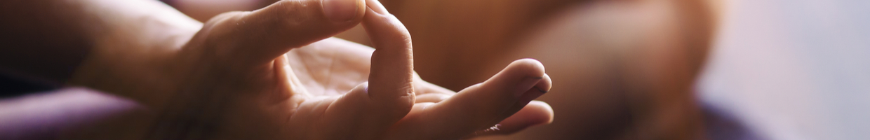 Close-up of hands in “vitarka mudra” during meditation.