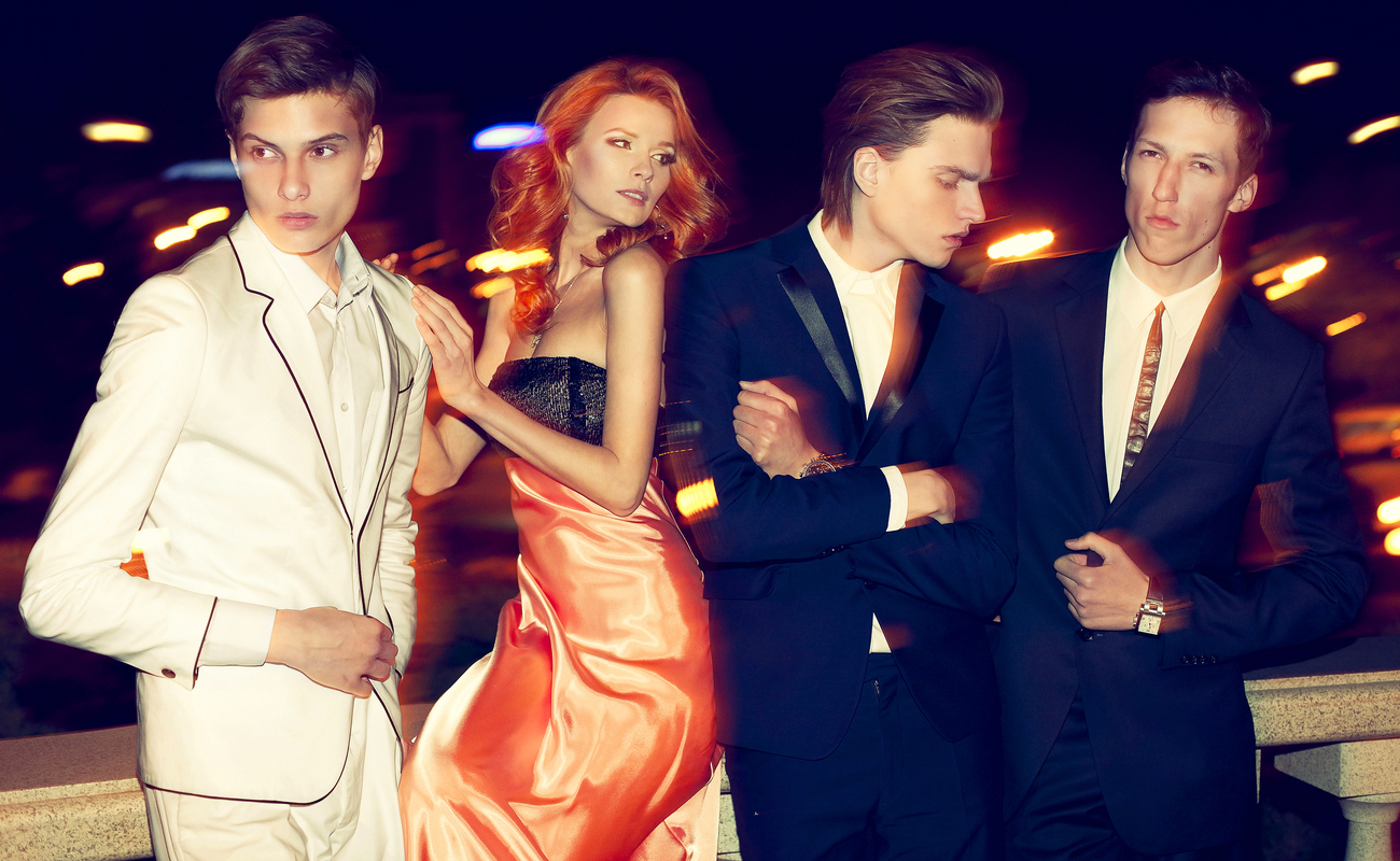Fashion-conscious men and women pose on a balcony.