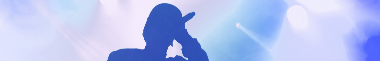 A silhouette of a singer performing with a blue background.