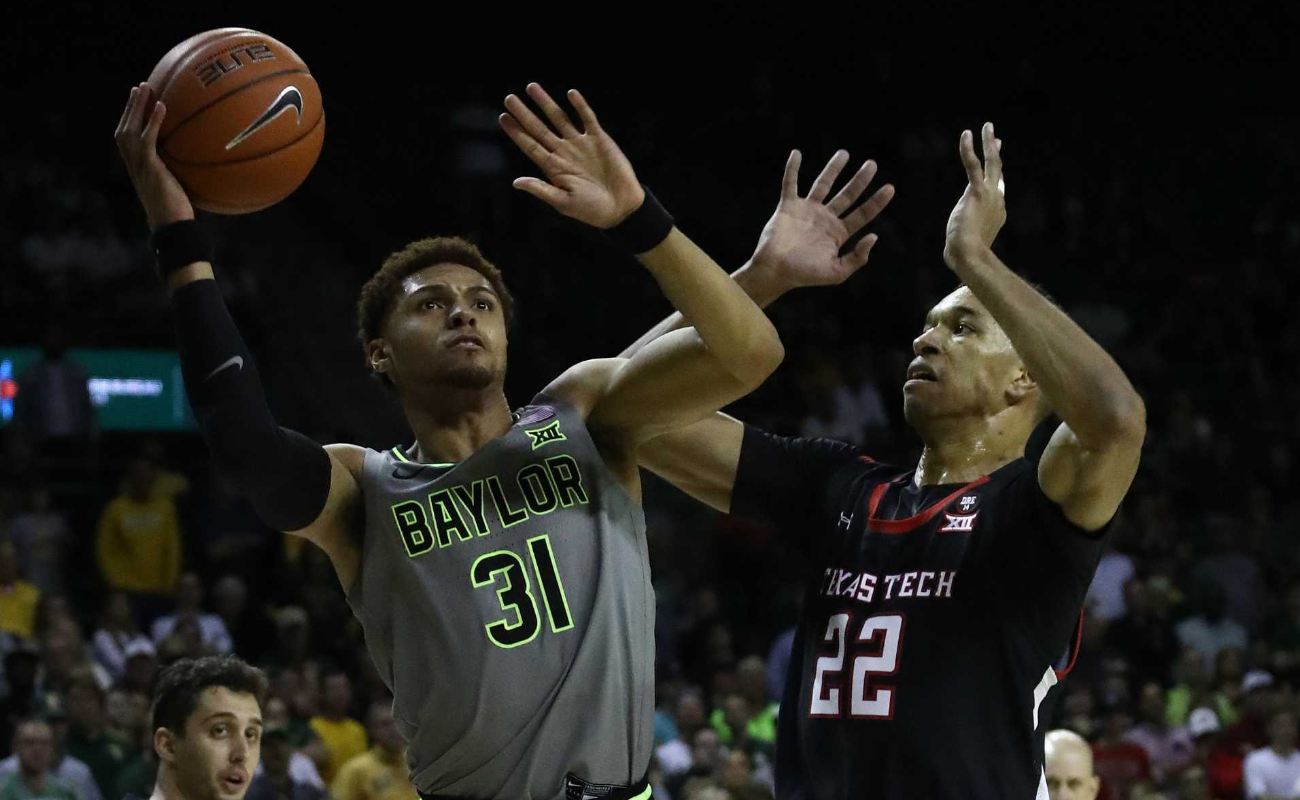 MaCio Teague #31 of the Baylor Bears takes a shot against TJ Holyfield #22 of the Texas Tech Red Raiders in the second half at Ferrell Center