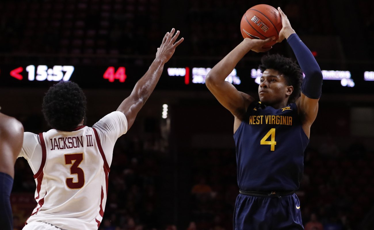 Miles McBride of West Virginia Mountaineers shoots basketball as Tre Jackson of Iowa State Cyclones blocks