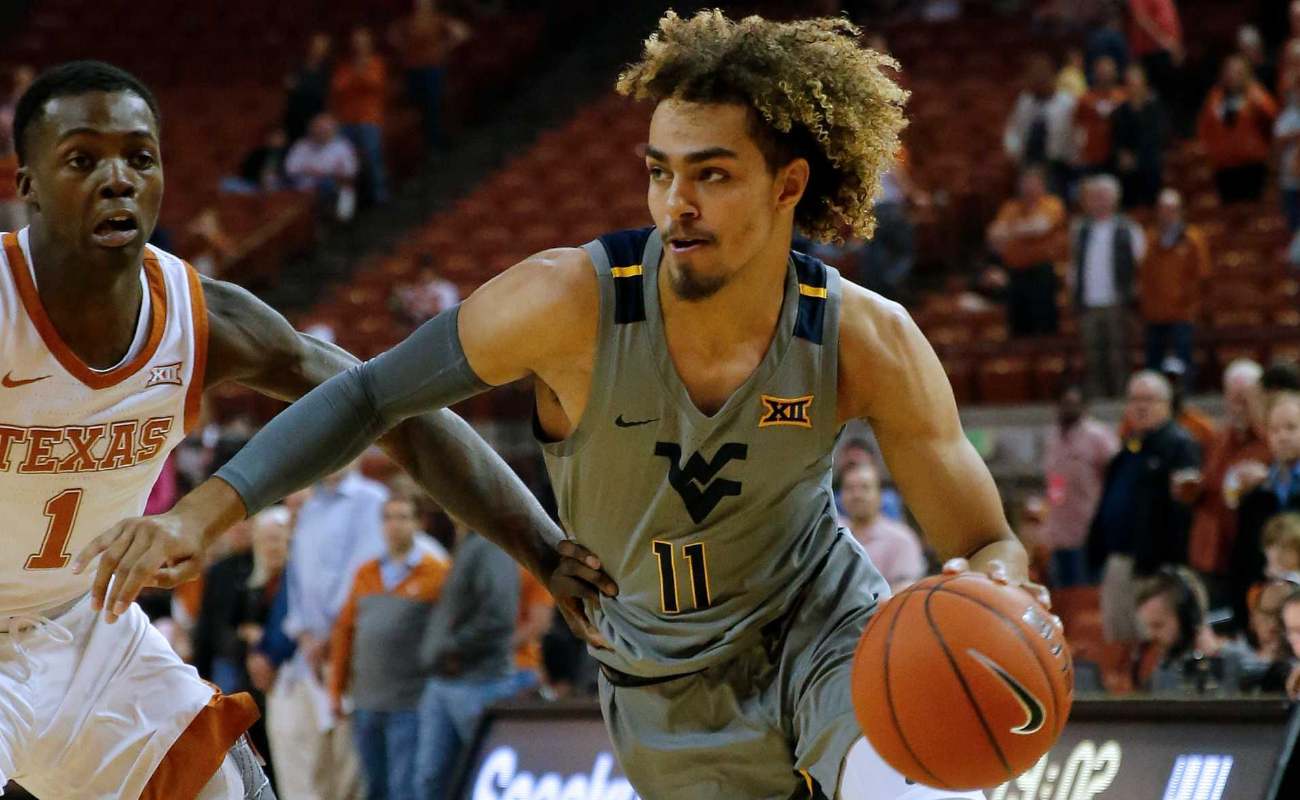 Emmitt Matthews Jr. ofWest Virginia Mountaineers drives around Andrew Jones of Texas Longhorns