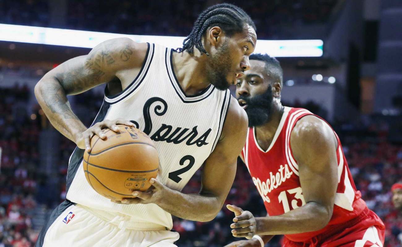 Kawhi Leonard #2 of the San Antonio Spurs and James Harden #13 of the Houston Rockets battle for position during their game at the Toyota Center