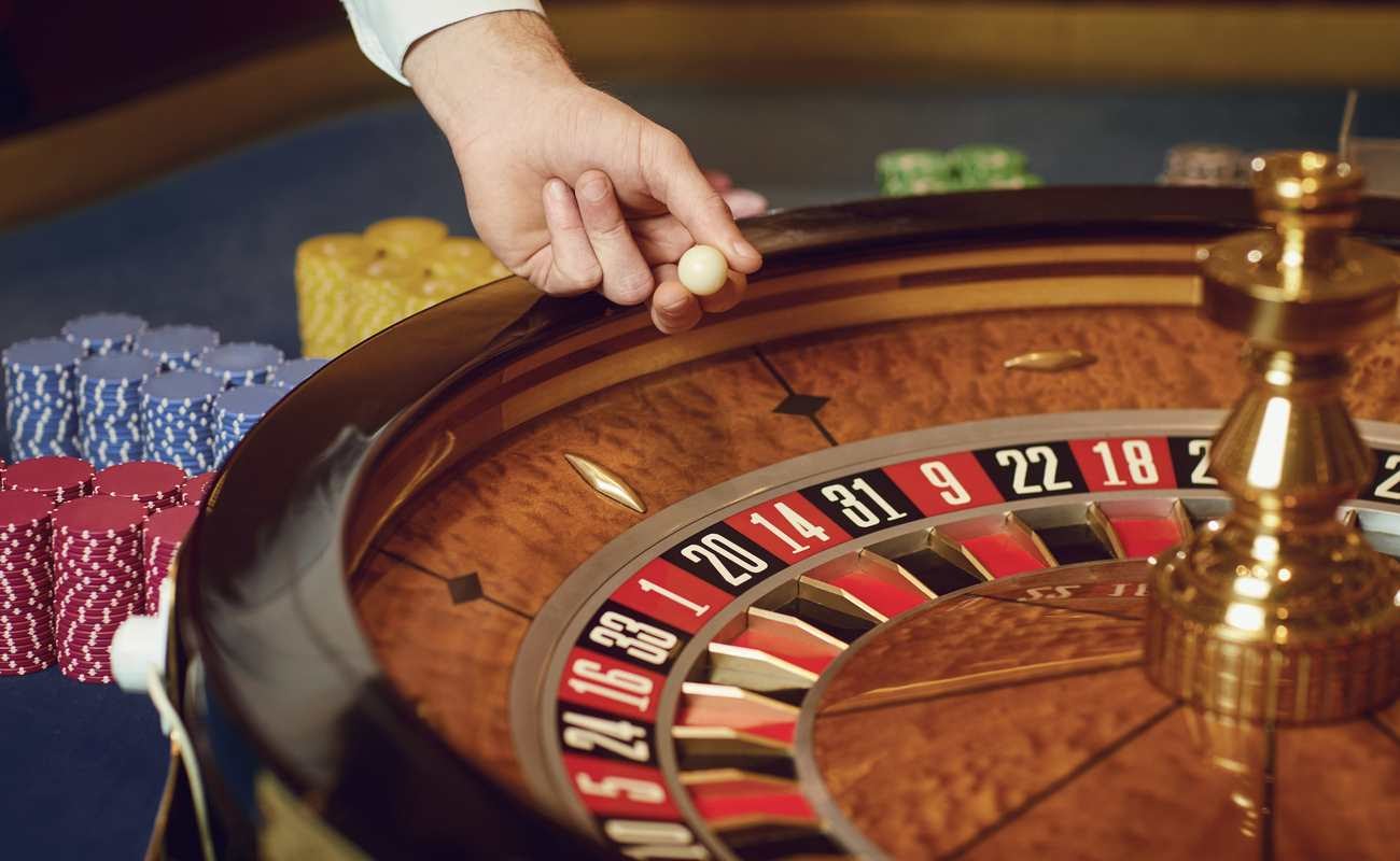 Croupier puts a roulette ball on the wheel at a casino