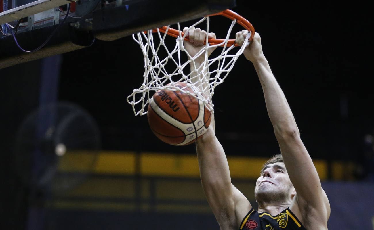 Ivan Basualdo of Obras dunks basketball in a game vs Olimpico.