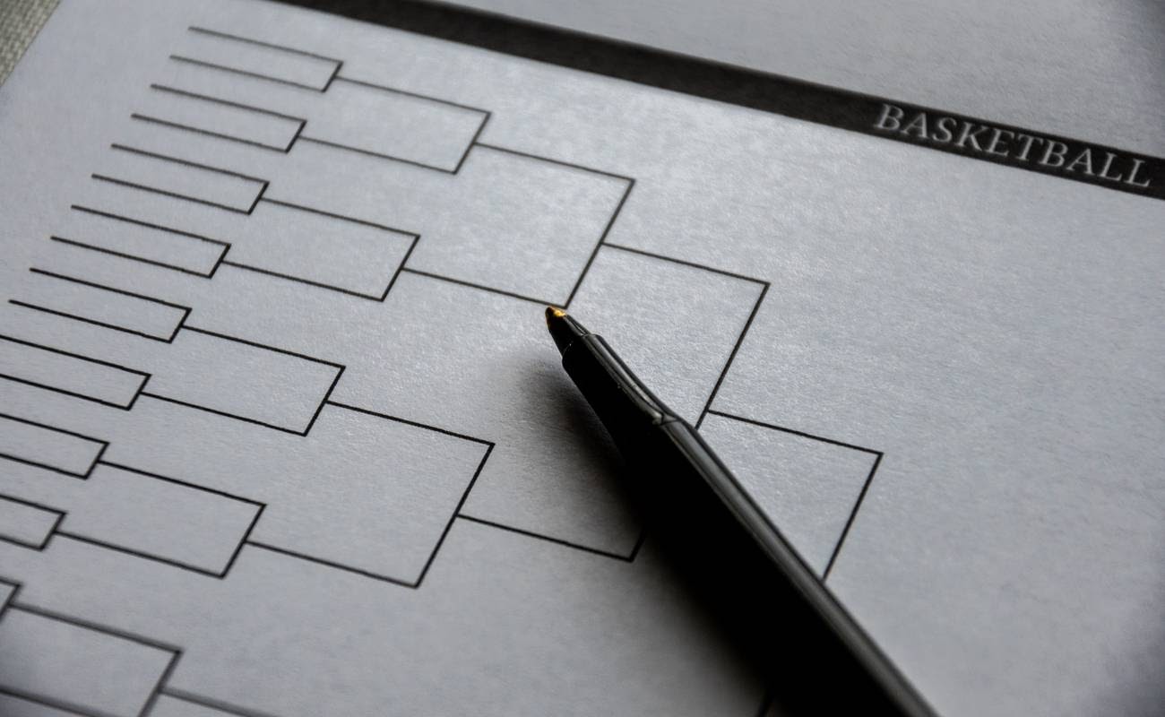 Blank basketball grid on paper and pen on top.