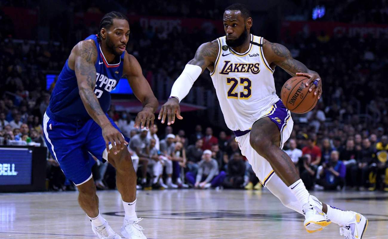 LeBron James #23 of the Los Angeles Lakers drives to basket past Kawhi Leonard #2 of LA Clippers
