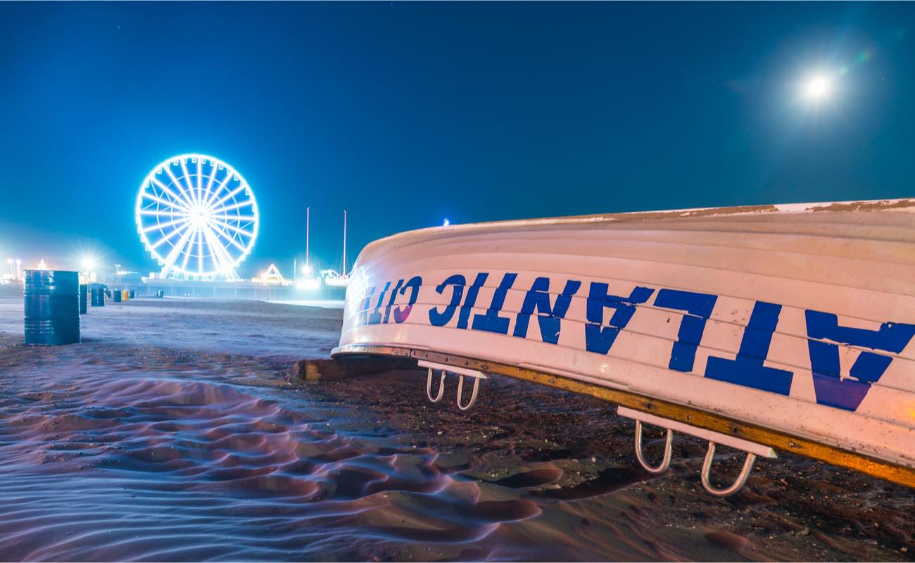 Atlantic City Boardwalk at night with overturned boat in foreground