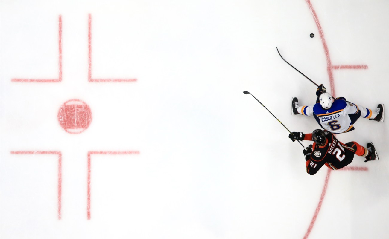 Ice hockey rink with David Backes of Anaheim Ducks battling with Marco Scandella of St Louis Blues for a puck