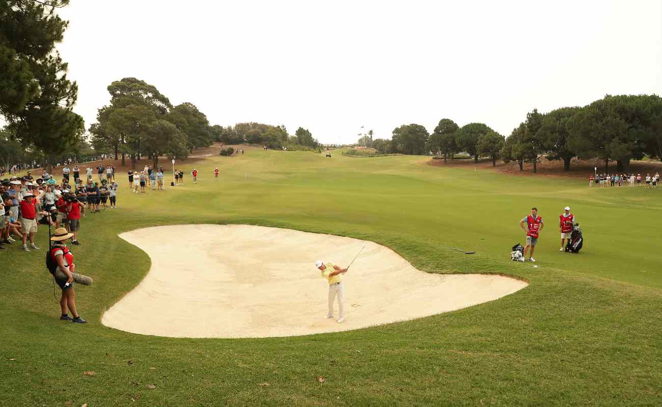 Fans watch golf player Paul Casey of England play out of a bunker at the 2019 Australian Open.