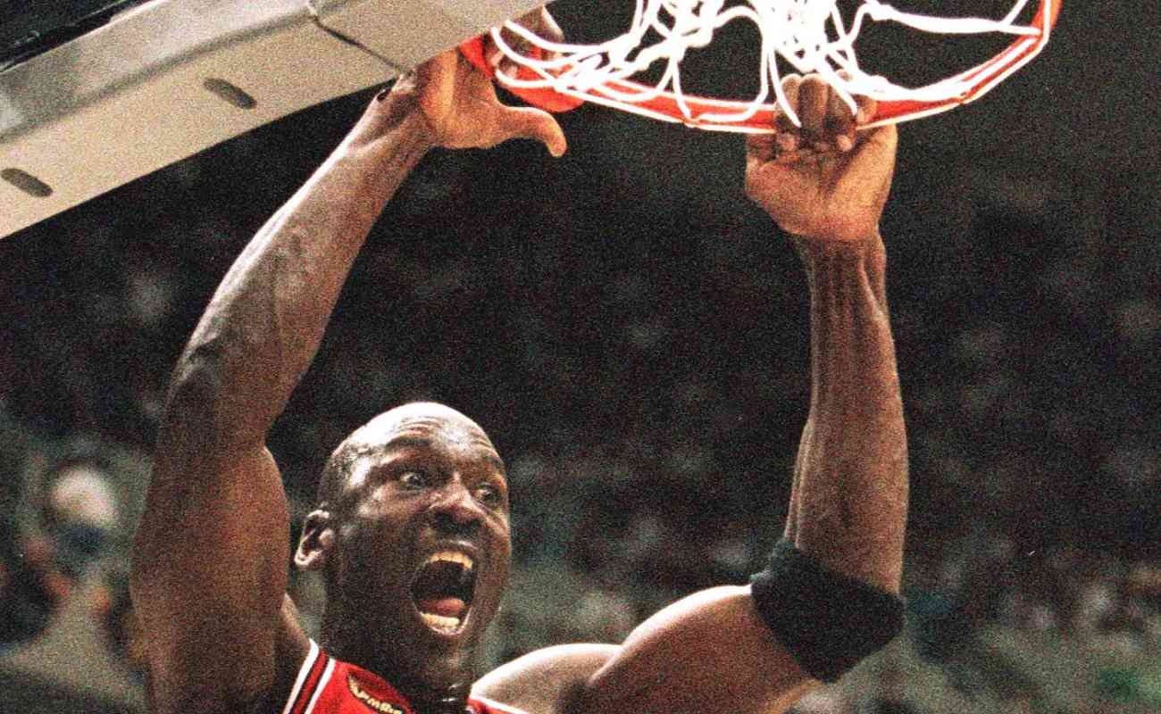 Michael Jordan of the Chicago Bulls hanging on the rim after a dunk