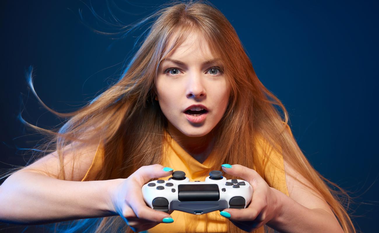 Excited girl playing video game with joystick