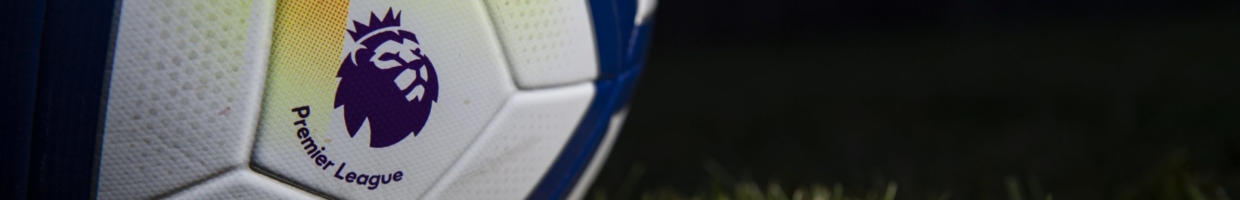 The Premier League logo printed on a match ball against a dark field background.