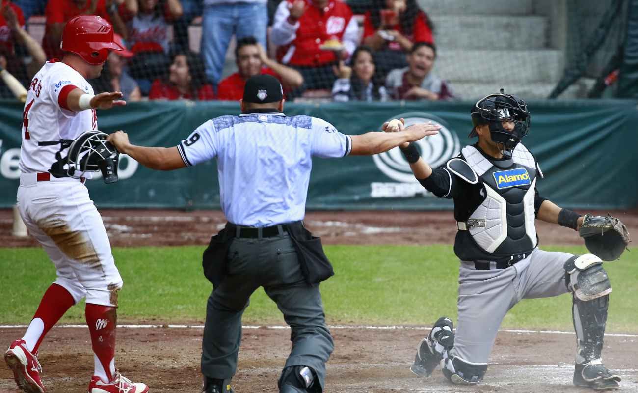 Ivan Terrazas of Diablos slides in home to score during the match between Rojos del Aguila and Diablos Rojos.