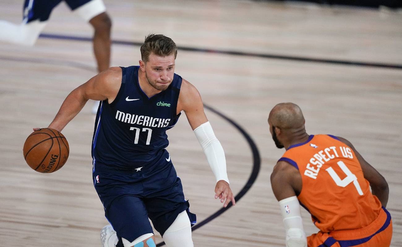 Luka Doncic of Dallas Mavericks drives against Jevon Carter of Phoenix Suns at ESPN Wide World Of Sports Complex in August 2020